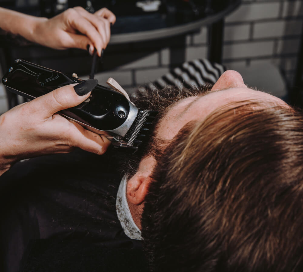 Barber performing beard trim in Lone Tree CO